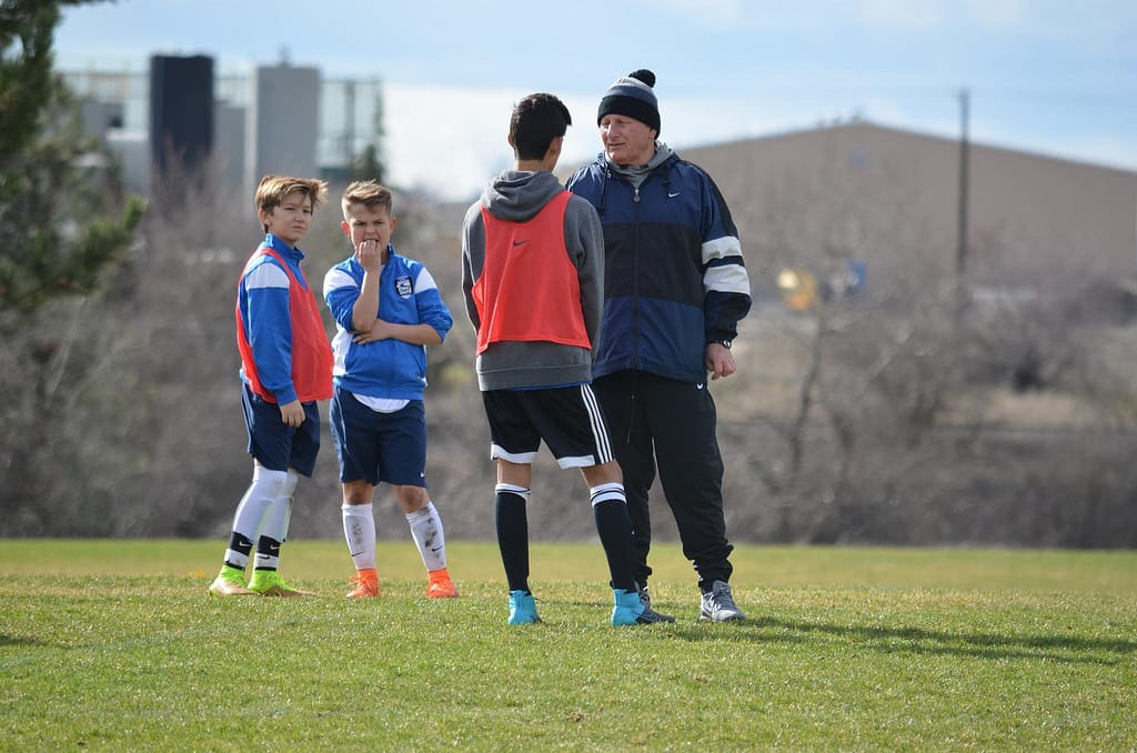Coach speaking to a player on field